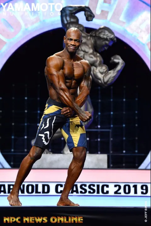 Antony Bessala en pose de profil sur la scene de l'Arnold Classic 2019