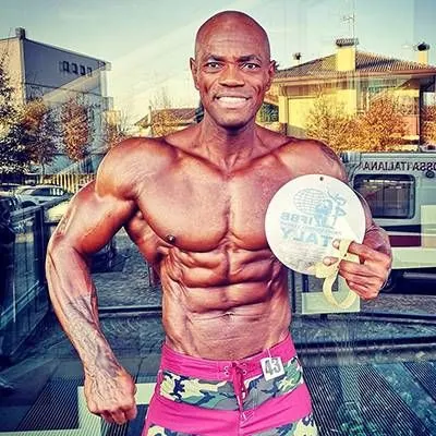 Antony Bessala tenant une medaille ronde IFBB Italie en exterieur