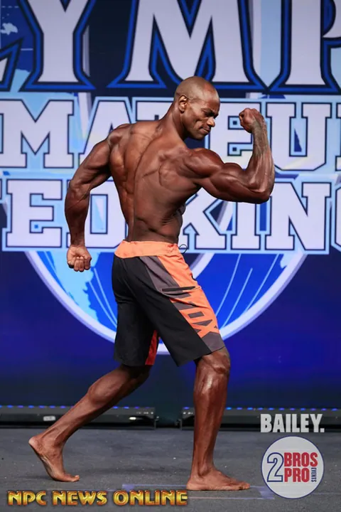 Antony Bessala en pose de biceps de profil a l'Olympia Amateur Royaume-Uni