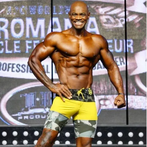 Antony Bessala souriant en short jaune au Romania Muscle Fest Pro